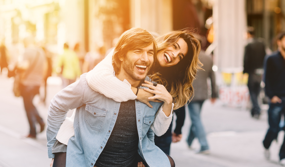 Young man carrying his girlfriend at piggyback